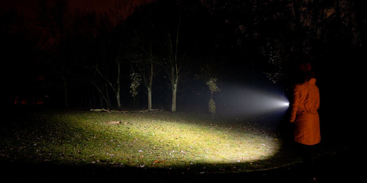 Latarka taktyczna NEWELL FL1000LUV USB-C z UV i laserem, Intuicyjna,sterowanie, Double Click, magnes, Latarka Newell FL1000LUV świecąca w ciemności w lesie