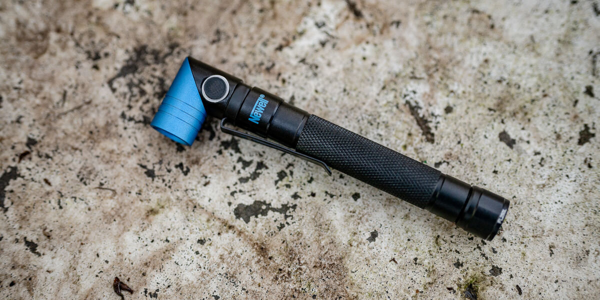 Latarka taktyczna NEWELL FL250L USB-C, światło, pogoda, warunki, odporność, Latarka Newell FL250L USB-C leżąca na betonie