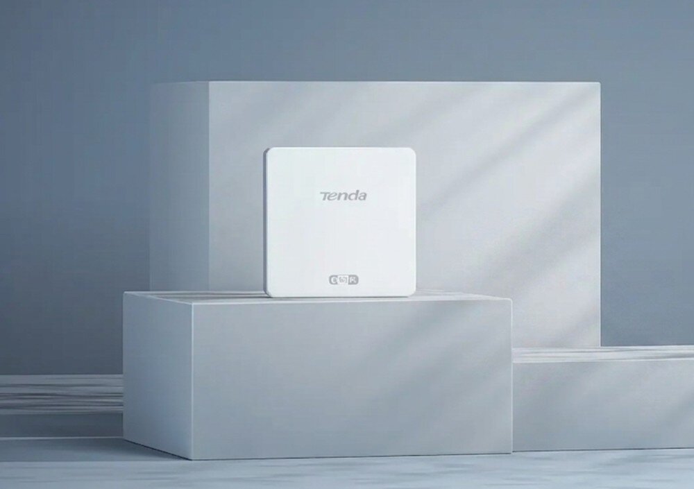 Punkt dostępu TENDA W15-Pro Kwadratowe urządzenie sieciowe z napisem 'Tenda' wyeksponowane na prostokątnym podwyższeniu w minimalistycznej aranżacji, opis