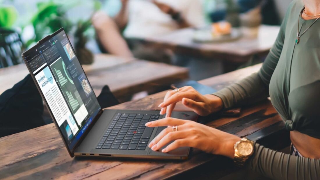 Laptop LENOVO ThinkPad Z16 G2 - Kobieta siedzi przy biurku, pisząc na laptopie LENOVO ThinkPad Z16 G2, koncentrując się na zadaniu.
