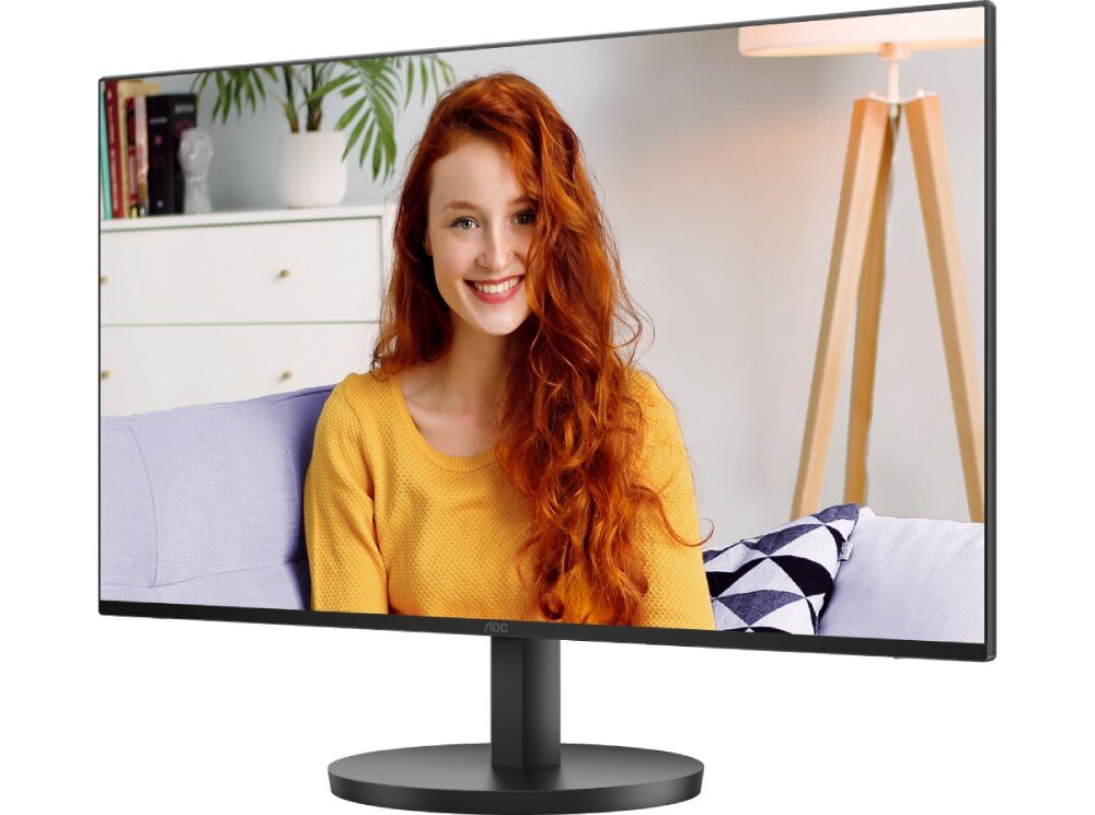 Monitor AOC 24B3CA2 Zdjęcie monitora z boku i z przodu, wyświetlającego rudej kobiecie w żółtej bluzce w domowym wnętrzu z roślinami