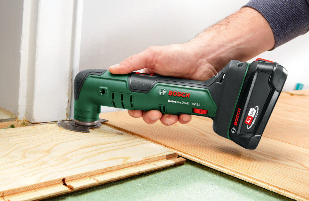 Narzędzie wielofunkcyjne BOSCH UniversalMulti 18V-32 pomieszczenie osoba trzyma narzędzie w dłoni podcina próg w drzwiach czterostopniowy ogranicznik głębokości ustawienie powtarzalnej wartości cięcia podnosi dokładność i zmniejsza ryzyko błędów