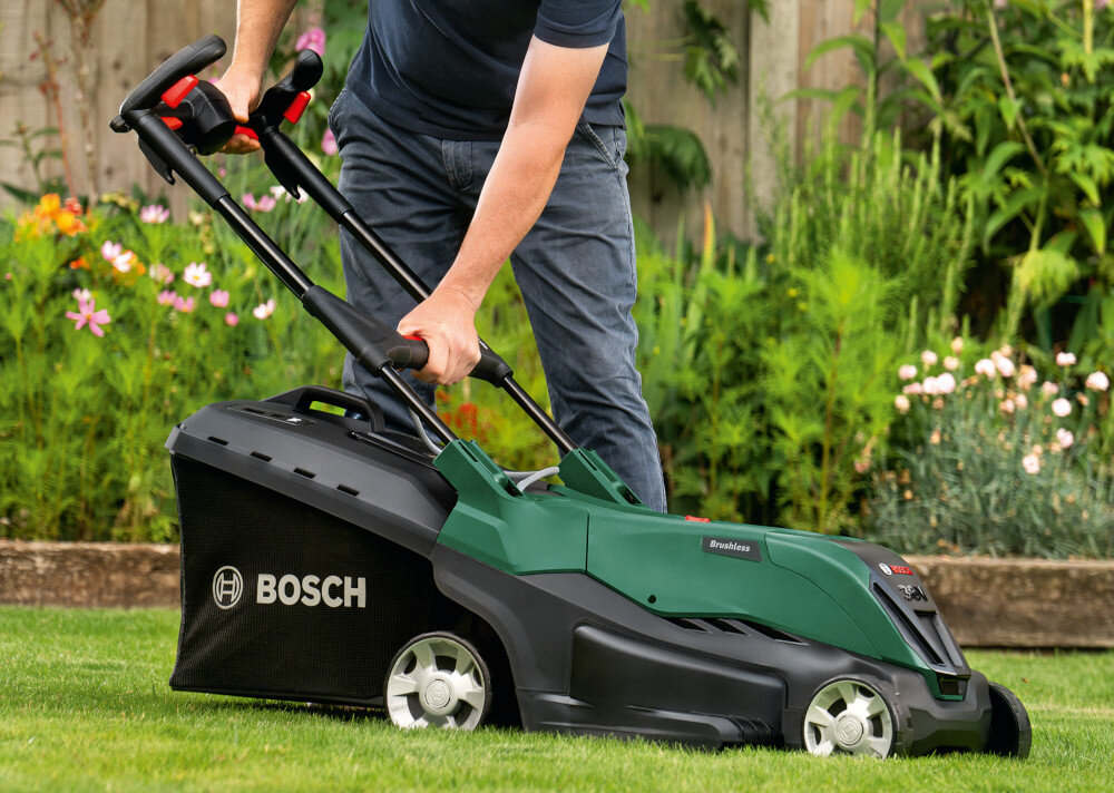 Kosiarka akumulatorowa BOSCH AdvancedlRotak 36V-40-650 06008B9F01 ogród trawnik osoba składa uchwyt w tle rośliny uchwyt typu Ergoflex zmniejsza obciążenie ramion pleców i barków praca w wyprostowanej pozycji system Ergoslide możliwość złożenia ułatwia przechowywanie