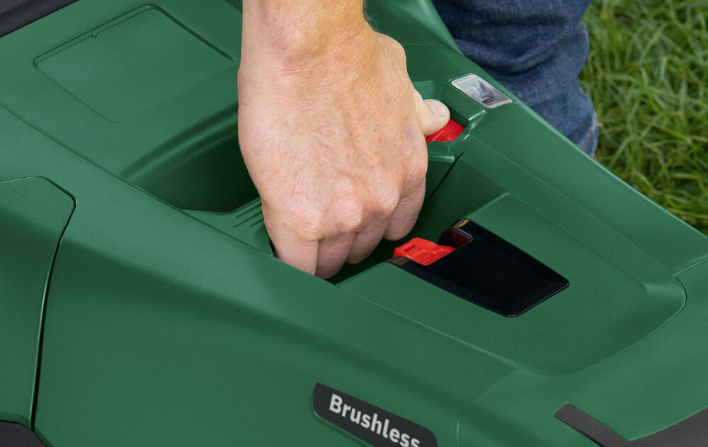 Kosiarka akumulatorowa BOSCH AdvancedlRotak 36V-44-750 06008B9G00 zbliżenie na uchwyt osoba trzyma kosiarkę za uchwyt waga 8,1 kg zintegrowany uchwyt do przenoszenia lepsze efekty koszenia łatwe prowadzenie intuicyjne sterowanie proste funkcje