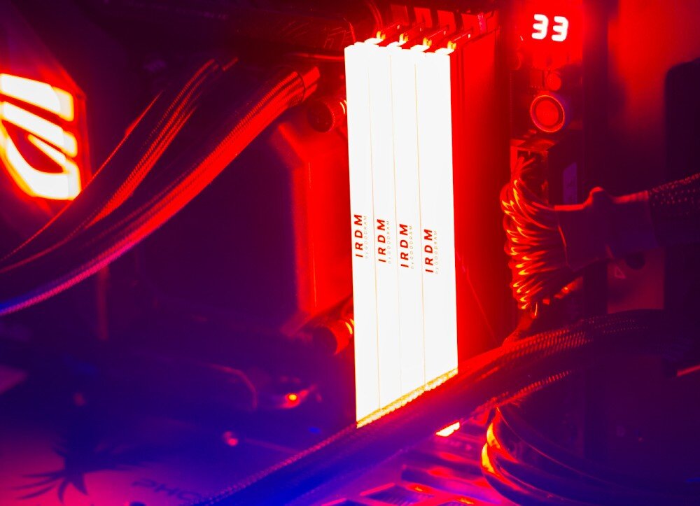Pamięć RAM GOODRAM IRDM RGB Cztery moduły pamięci zamontowane w płycie głównej, świecące silnym czerwonym światłem, widoczne czerwone refleksy w otoczeniu