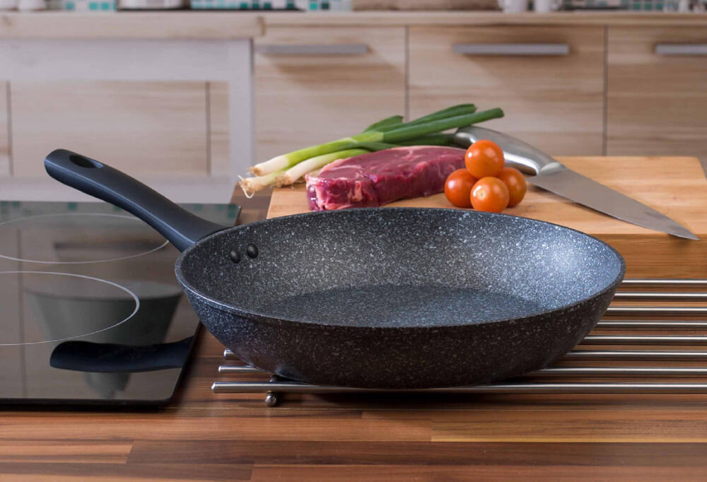 Patelnia SALTER Megastone BW05747S 28 cm Beztłuszczowa patelnia stoi na kratce na blacie szara marmurkowa czarny uchwyt praktyczność estetyka wygodne gotowanie solidna konstrukcja powłoka wolna od PFOA bezpieczne komfortowe przygotowanie posiłków przemyślany design funkcjonalność szybkie smażenie duszenie potraw