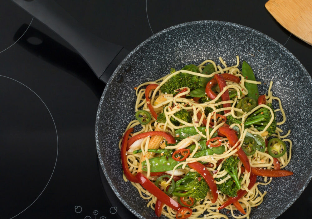 Patelnia SALTER Megastone BW06524S 30 cm Beztłuszczowa patelnia stoi na płycie potrawa z makaronem w środku szara marmurkowa patelnia czarny uchwyt wszechstronność do wszystkich rodzajów płyt grzewczych indukcyjne mycie w zmywarce używanie metalowych przyborów kuchennych specjalna powłoka kamienna resztki jedzenia nie przywierają do powierzchni szybkie i bezproblemowe czyszczenie wygoda funkcjonalność oszczędność czasu w kuchni