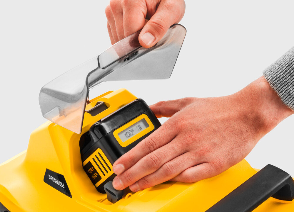 Kosiarka akumulatorowa KARCHER LMO 2-18 1.445-400.0 białe tło osoba wyciąga akumulator z kosiarki należy do platformy bateryjnej 18 V KARCHER Battery Power oszczędność czasu i pieniędzy z akumulatorem o pojemności 5,0 Ah czas pracy maksymalnie do 28 minut