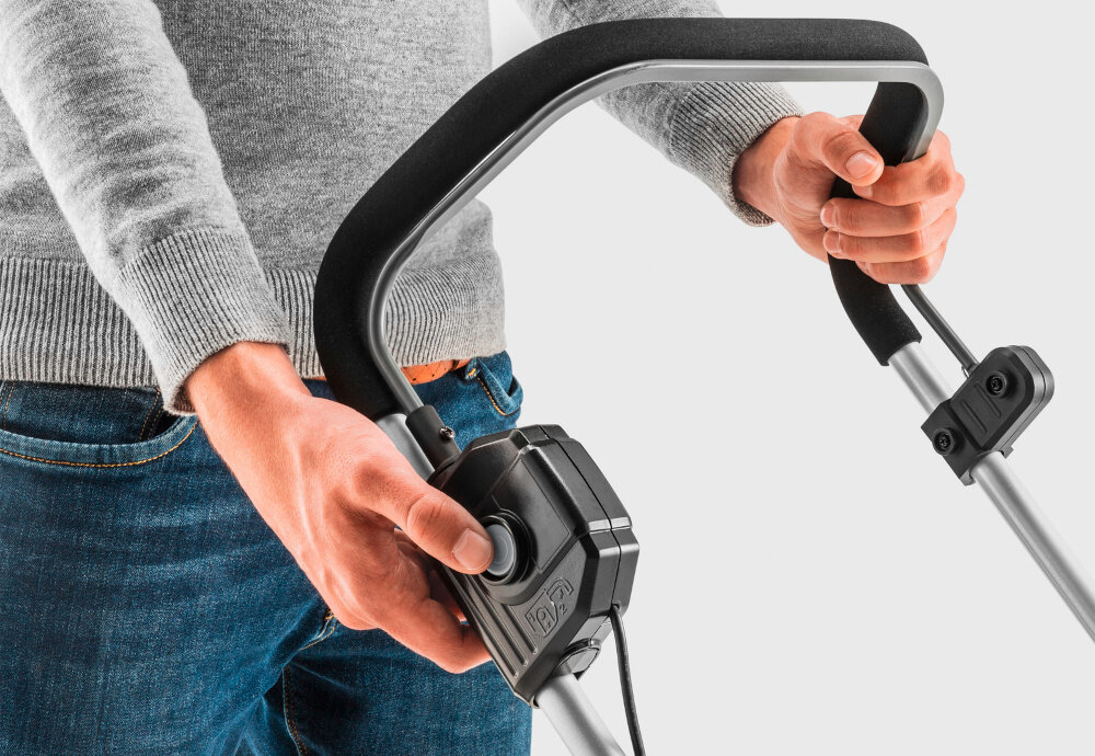 Kosiarka akumulatorowa KARCHER LMO 2-18 1.445-400.0 jasne tło zbliżenie na rozrusznik osoba trzyma dłoń na rozruszniku platforma bateryjna KARCHER Battery Power 18 V silnik bezszczotkowy wysoka wydajność pracy prędkość obrotowa do 3500 obr./min do trawników o powierzchni do 250 m²