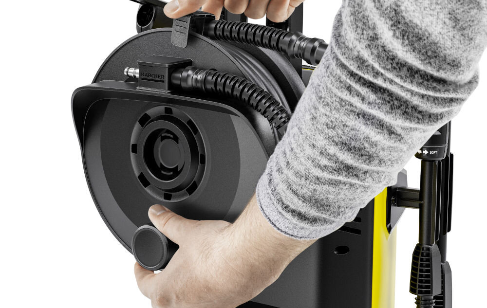 Osoba trzyma czarną część myjki ciśnieniowej z widocznym logo \'KARCHER\'.