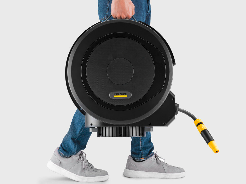 Bęben na wąż KARCHER HBX 5.35 Automatic jasne tło osoba trzyma w dłoni bęben widok bokiem ergonomiczny uchwyt waga 13 kg system FlexChange szybkie odłączenie bez narzędzi i śrub