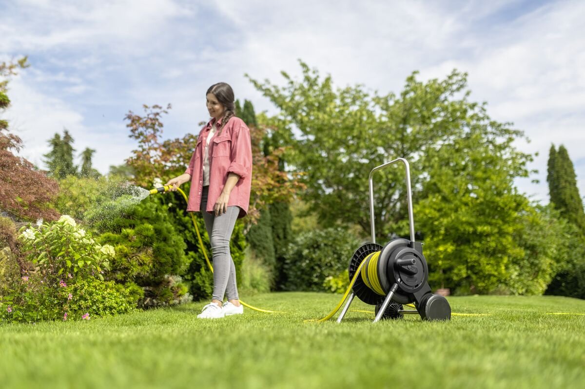 Wózek KARCHER z wężem HT 2.20 2.645-362.0, wózek, wąż, ogród, podlewanie, Kobieta podlewa rośliny w ogrodzie używając węża.