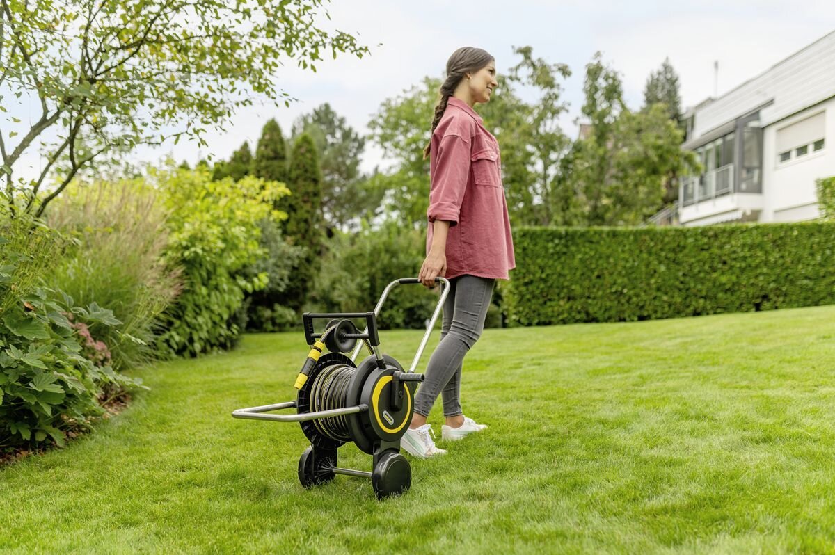 Wózek KARCHER z wężem HT 4.20 2.645-366.0, odporność, uv, trwałość, warunki, Kobieta transportuje wózek z wężem po trawie.