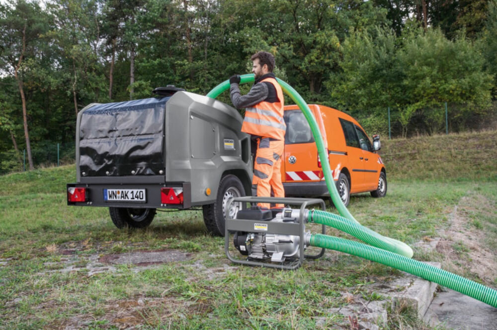 Wąż odpływowy KARCHER Professional L 10m 2.645-341.0 pompa do brudnej wody Kärcher, w tle pomarańczowy samochód i pracownik