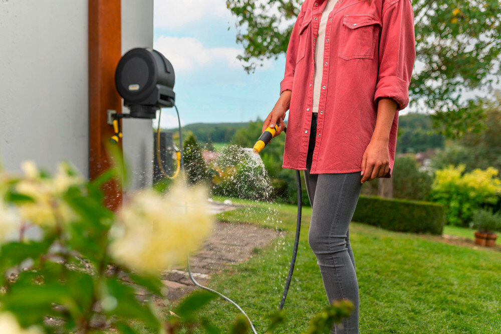 Bęben na wąż KARCHER HBX 5.30 Automatyczny 2.645-380.0 ogród osoba podlewa rośliny w ogrodzie w tle drzewa krzewy kwiaty niebo akcesoria do podlewania wąż przyłączeniowy o długości 1,5 m spryskiwacz dwa rodzaje strumienia strumień stożkowy strumień punktowy