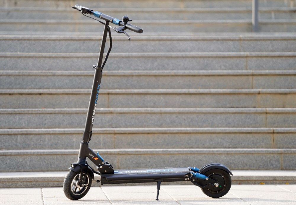 Hulajnoga elektryczna SKATEFLASH Echo 40km 350W 8 cali Czarny miasto schody hulajnoga widoczna z boku stoi na chodniku oparta na stopce aluminiowa konstrukcja wytrzymałość lekkość szeroki deck z antypoślizgową nawierzchnią maksymalne obciążenie do 120 kg stabilność wygoda