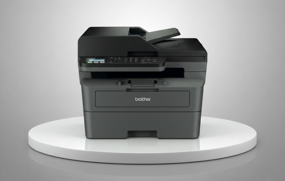 Urządzenie wielofunkcyjne BROTHER MFC-L2802DN Automatyczny druk dwustronny prezentacja urządzenia na podeście na jasnym tle interfejs USB sprawne przesyłanie danych prosta konfiguracja standard USB efektywna obsługa dokumentów
