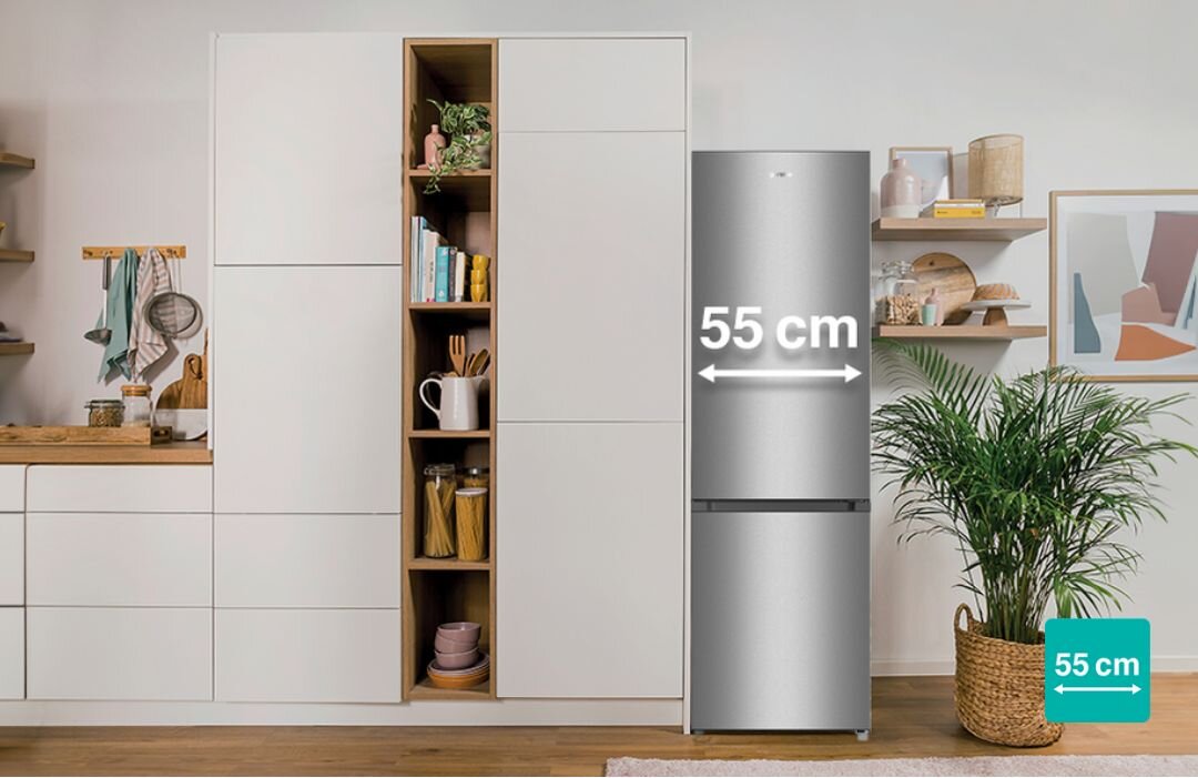 LODÓWKA GORENJE RK416DPS4 Aranżacja kuchni z wysoką zabudową i wolnostojącą lodówko-zamrażarką Gorenje, na której froncie zaznaczono szerokość 55 cm białym napisem i strzałkami, a w rogu znajduje się ikonka z oznaczeniem „55 cm” chłodziarko-zamrażarka 55 cm mała kuchnia niewielka przestrzeń pojemność komfort użytkowania