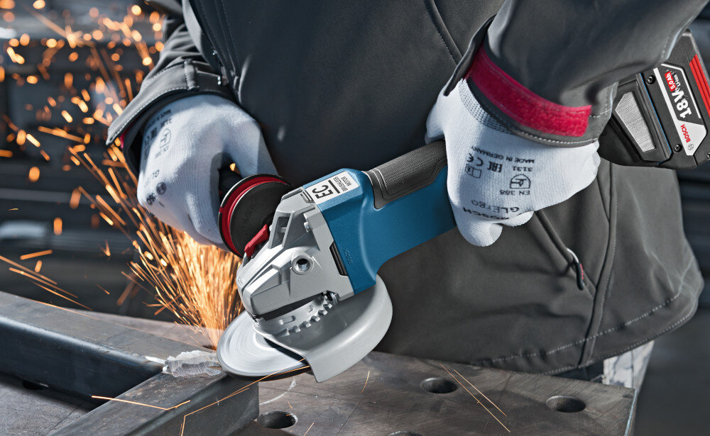Szlifierka kątowa BOSCH Professional GWS 18V-10 P 06019J4101 osoba trzyma szlifierkę w dłoniach szlifuje metalowy element osłona szybka regulacja ochrona operatora przed iskrzeniem kontrola emisji pyłu łatwe dopasowanie do własnych preferencji bez korzystania z dodatkowych narzędzi