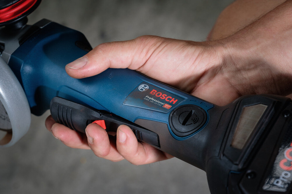 Szlifierka kątowa BOSCH Professional GWS 18V-10 P 06019J4101 zbliżenie na rękojeść osoba trzyma szlifierkę w dłoni ergonomiczna konstrukcja rękojeści niska waga 1,9 kg wygodna obsługa ergonomiczna rączka o bardzo małym obwodzie powłoka typu SoftGrip