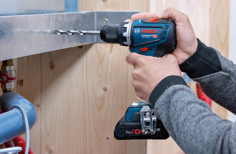 Wiertarko-wkrętarka BOSCH GSR 18V-90 FC Professional (06019K6205) pomieszczenie osoba wierci otwór w metalowej listwie waga około 0,92 kg bez akumulatora smukła rękojeść typu T krótki korpus (136 mm) można operować jedną ręką użytkownik może pracować dłużej bez zmęczenia poprawia tempo montażu minimalizuje ryzyko błędów i konieczności poprawek