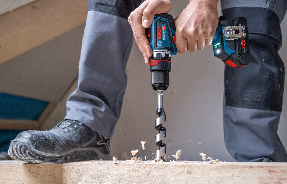 Wiertarko-wkrętarka BOSCH GSR 18V-90 FC Professional (06019K6200) pomieszczenie osoba wierci otwór w drewnianej desce funkcja KickBack Control minimalizuje ryzyko urazów możliwość włączenia lub wyłączenia pozwala dopasować poziom bezpieczeństwa praca jest bezpieczniejsza pełna kontrolę