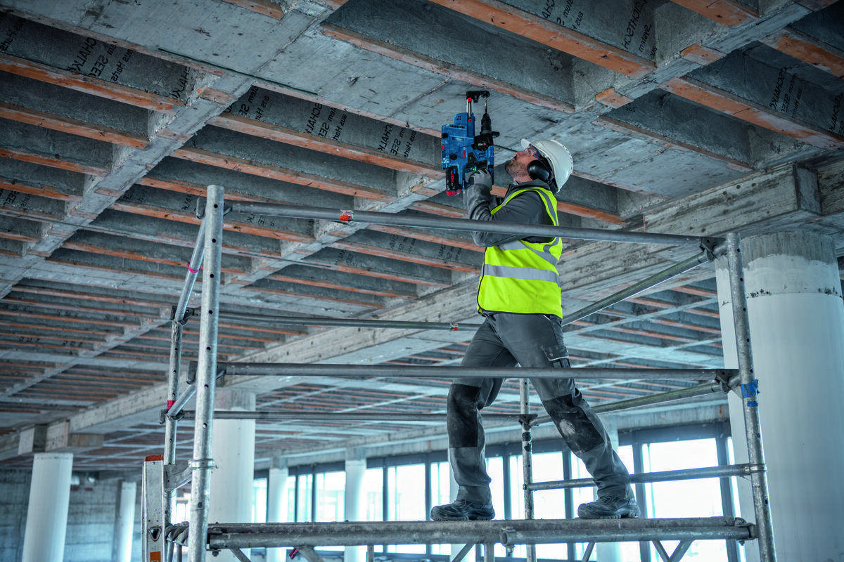 BOSCH GBH 18V-28 C BOSCH GBH 18V-28 C system Vibration Control młotami bez tłumienia drgań - Mężczyzna wierci otwór w suficie przy pomocy urządzenia