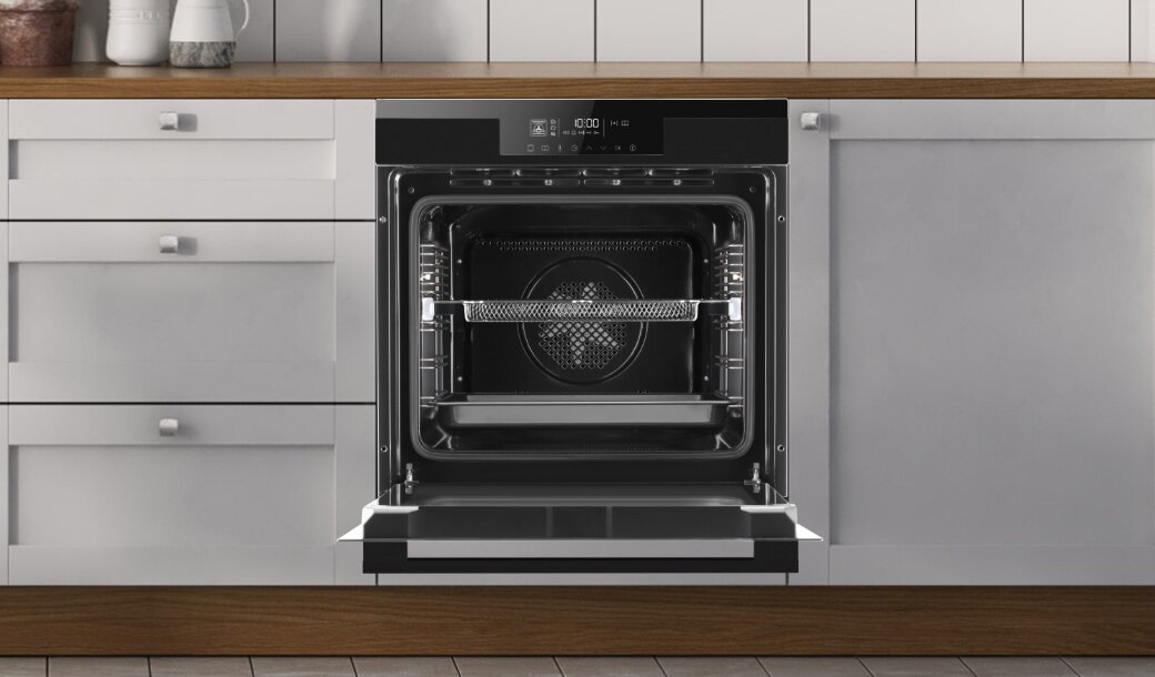 Piekarnik Amica w pozycji włączonej w jasnej zabudowie kuchennej z uchwytami