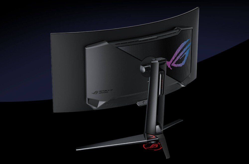 Monitor ASUS ROG Swift PG34WCDM Widok z tyłu na zakrzywiony monitor z futurystycznym designem. Na obudowie znajduje się podświetlane logo oraz otwory wentylacyjne. Monitor stoi na stabilnej podstawie z podświetleniem LED, wygląd, styl, ramka