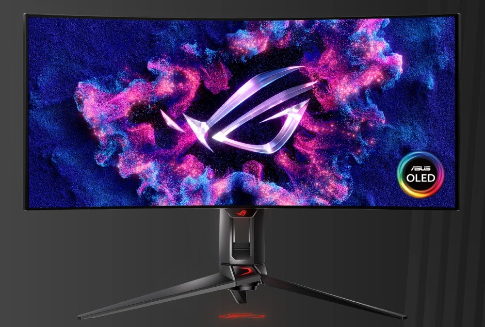 Monitor ASUS ROG Swift PG34WCDM Monitor na biurku z podświetlonym logo na ekranie, otoczonym efektami różowo-niebieskich chmur. W dolnym rogu ekranu widnieje kolorowy emblemat z napisem OLED, jednolita jasność