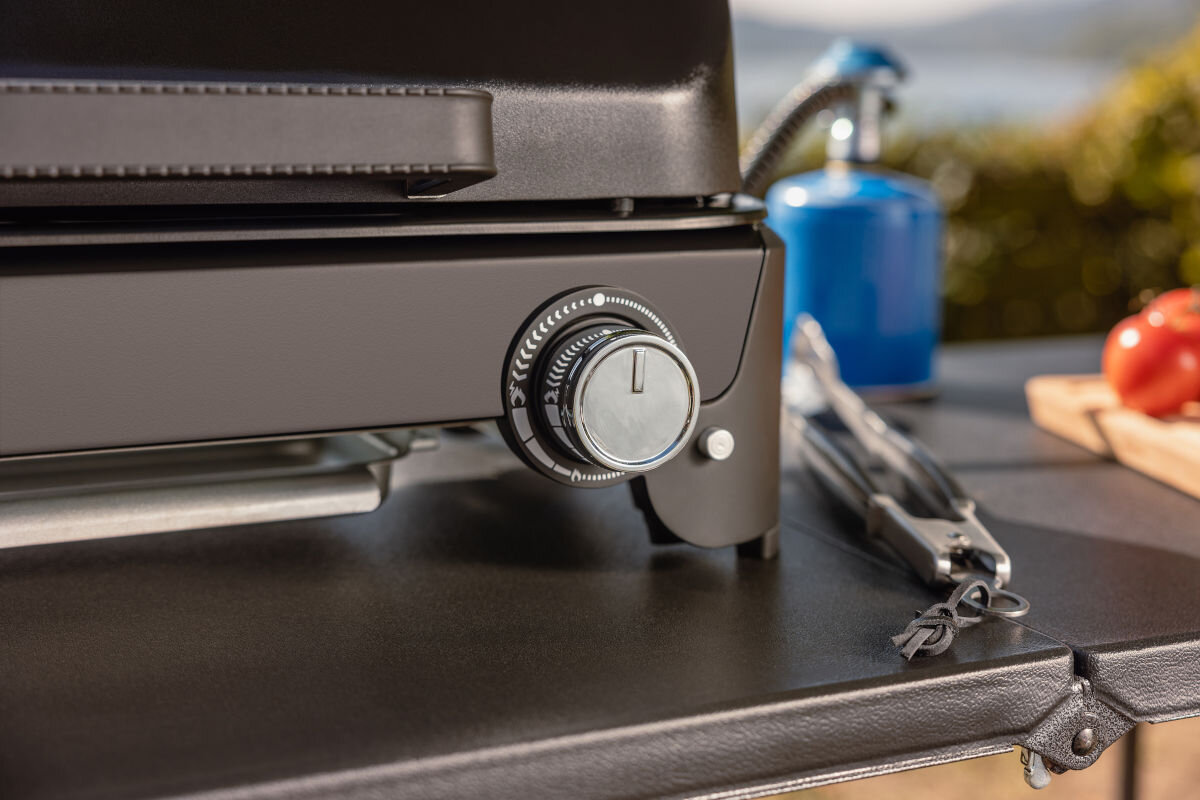 Grill gazowy CAMPINGAZ Tour and Grill 2.4 kW 47 x 25.5 cm, podróż, kemping, zasilanie, kartusz, zbliżenie na regulator grilla, w tle kartusz