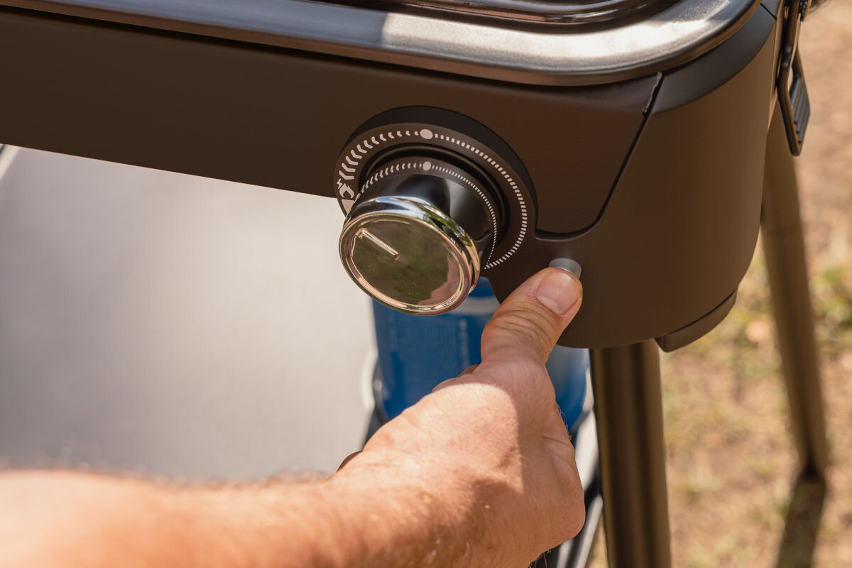 Grill gazowy CAMPINGAZ Tour and Grill 2.4 kW 47 x 25.5 cm, zapalarka, piezo, zapałki, eleminowanie, palec dłoni przyciska zapalnik piezo na grillu