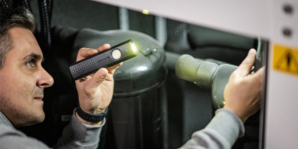 Latarka LEDLENSER W5R Work,Sprzęt dla profesjonalistów, Mężczyzna podświetla instalacje