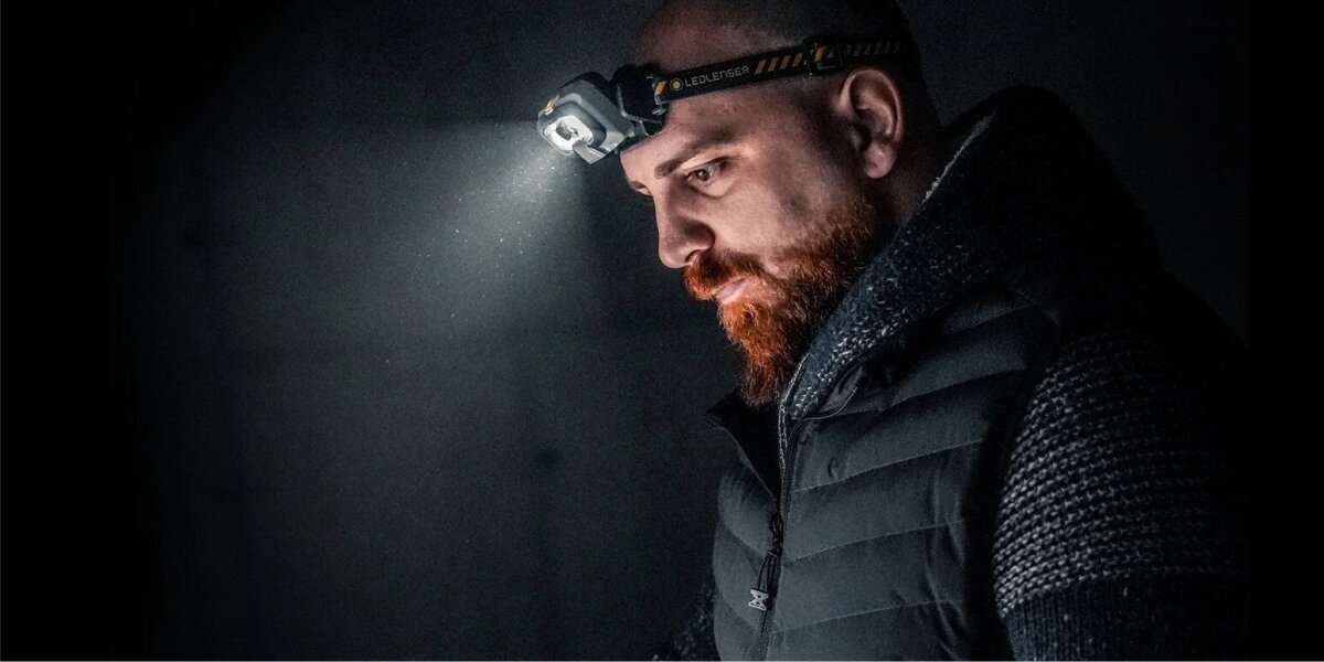 Latarka czołowa LEDLENSER HF8R Work, Potężne narzędzie pracy, Mężczyzna z latarką na czole