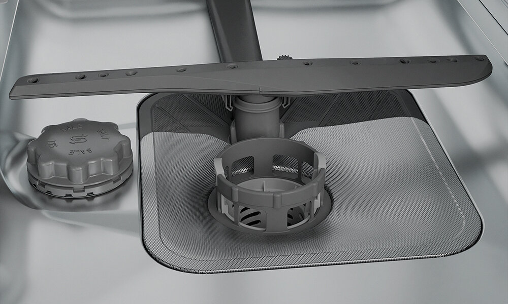 ZMYWARKA WHIRLPOOL WI9E 2B19 Zbliżenie na dno komory zmywarki ukazuje filtr, sito oraz ramię spryskujące na tle stalowego wnętrza. Kadr podkreśla łatwy dostęp do elementów odpowiedzialnych za filtrację i rozprowadzanie wody stal nierdzewna komora odporność na korozję trwałość urządzenia łatwe czyszczenie higiena wnętrza