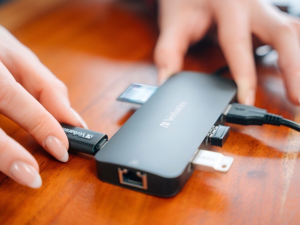Hub Verbatim 32152 Zbliżenie na adapter z podłączonymi urządzeniami, widoczne złącza USB, HDMI, Ethernet i karta pamięci, 
            hub obudowa aluminium trwałość wygląd kompaktowy design