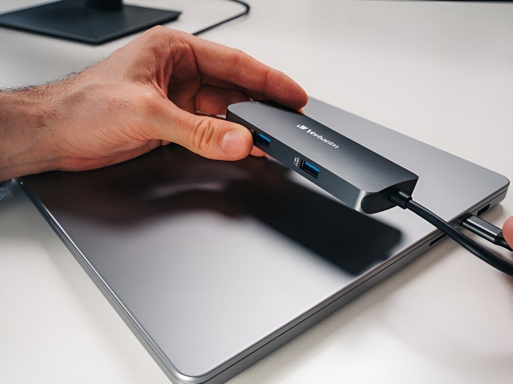 Hub Verbatim 32150 Dłoń trzymająca adapter z dwoma portami USB, spoczywający na zamkniętym laptopie,
hub usb transfer 5gb/s przesyłanie pliki