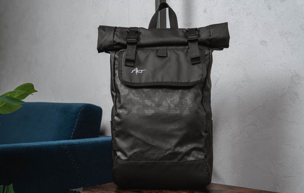 Plecak na laptopa ART BP-8879 15.6 cali prezentacja plecaka od przodu na ławce w pomieszczeniu jasna ściana w tle niebieska kanapa i kawałek rośliny ergonomiczna konstrukcja jazda na rowerze hulajnodze motocyklu wygoda w ruchu