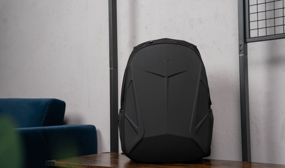 Plecak na laptopa ART BP-8948 15.6 cali prezentacja plecaka od przodu na ławce w pomieszczeniu jasna ściana w tle niebieska kanapa ergonomiczna konstrukcja jazda na rowerze hulajnodze motocyklu wygoda w ruchu