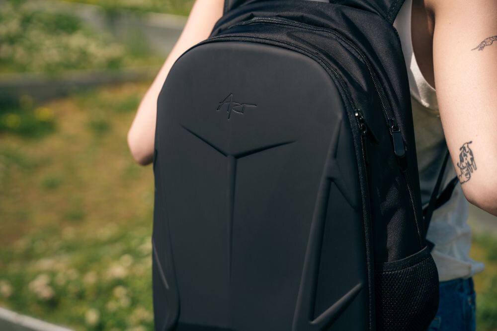 Plecak na laptopa ART BP-8948 15.6 cali prezentacja plecaka założonego na plecach kobiety stojącej w parku solidne metalowe suwaki odporność