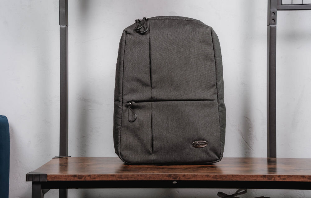 Plecak na laptopa ART BP-8723 14.1 cali prezentacja plecaka od przodu na ławce w pomieszczeniu jasna ściana wymiary plecaka 39,5 × 27 × 11 cm codzienne użytkowanie ułatwia przechowywanie wygoda