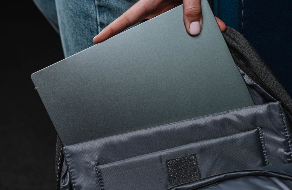 Plecak na laptopa ART BP-8723 14.1 cali prezentacja wnętrza otwartego plecaka kobieta wyciągająca laptopa komora na laptop rozmiar wyściełana ochrona urządzenia stabilne osadzenie sprzętu