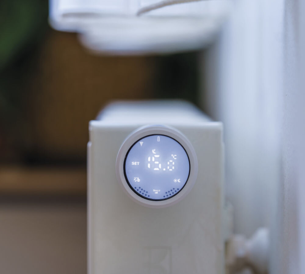 Głowica termostatyczna EMOS GoSmart P5630S, ciepło, ogrzewanie, regulacja, temperatura, zbliżenie na głowicę zamontowaną do kaloryfera w pokoju