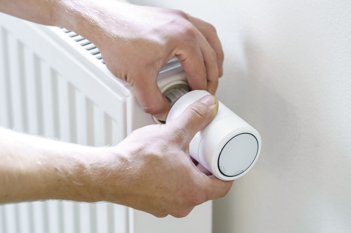 Głowica termostatyczna EMOS GoSmart P5630S, zawory, pasuje, narzędzia, instalacja, dłonie montują głowicę do kaloryfera w pokoju dziennym