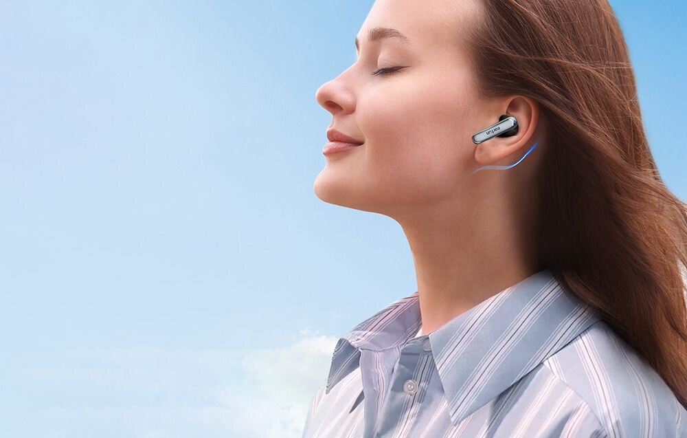 Słuchawki dokanałowe EARFUN Air 2 NC tryb gry 0 055 s niskie opóźnienie synchronizacja audio wideo, osoba z założonymi słuchawkami na błękitnym tle