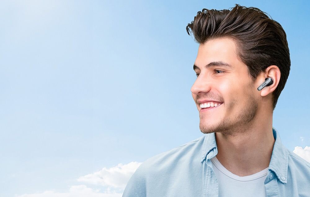 Słuchawki dokanałowe EARFUN Air 2 NC tryb kinowy 3D Theater Mode przestrzenny dźwięk filmowy, osoba z założonymi słuchawkami na błękitnym tle