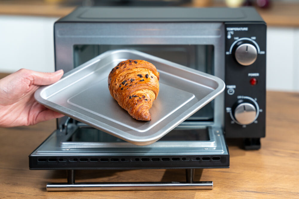 Piekarnik GOTZE & JENSEN MP210 rogalik na blaszce na tle otwartego piekarnika