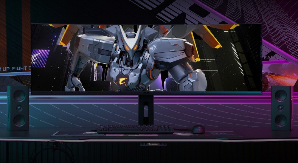 Monitor GIGABYTE AORUS CO49DQ Monitor ustawiony na biurku w ciemnym pomieszczeniu, na ekranie widoczny futurystyczny robot. Po obu stronach monitora ustawione są kolumny głośnikowe, głośniki, porty, podłączenie, hub USB