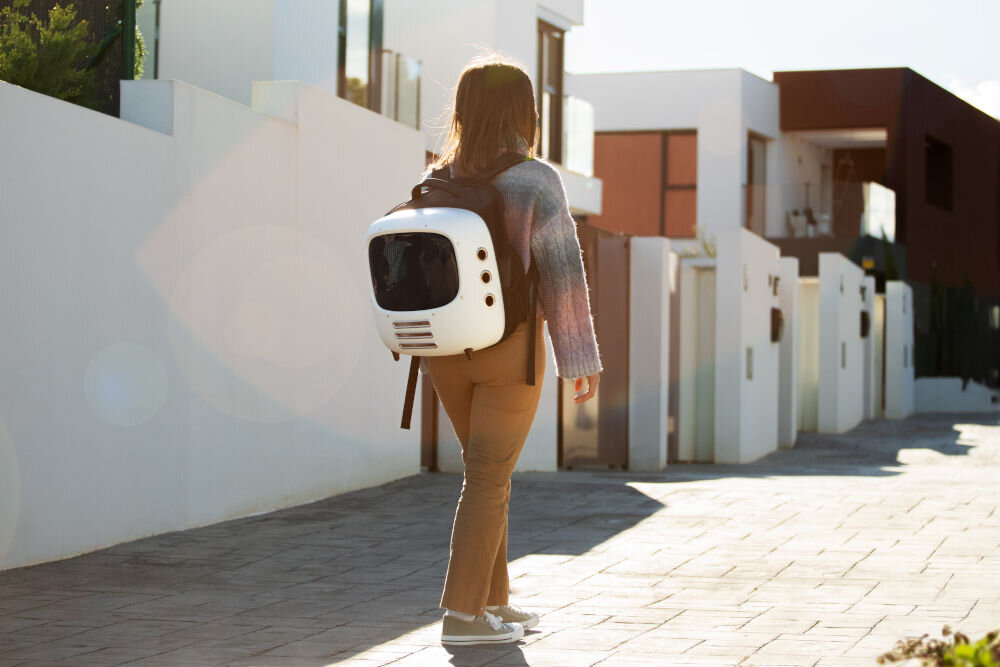 Transporter dla psa i kota CECOTEC Pumba 1800 Travel Fan 09564 osoba idąca z transporterem na plecach cyrkulacja powietrza system wentylacji oświetlenie progresywne wewnętrzne