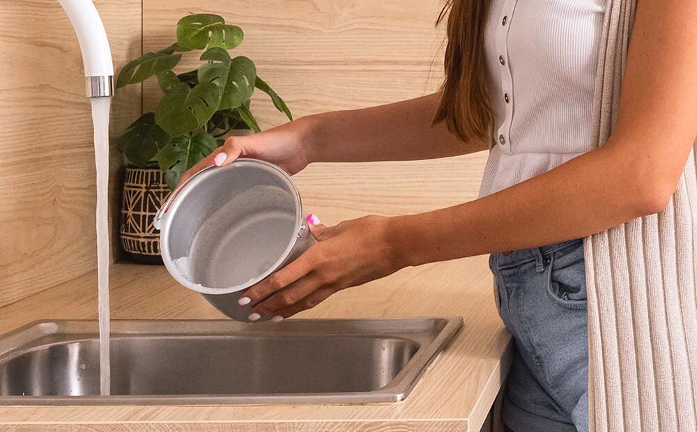 Maszynka do lodów CECOTEC Gelacy 1200 Touch osoba czyści ubrudzoną miskę pod bieżącą wodą łatwe czyszczenie wyjmowany silnik dostęp do wszystkich części łatwe wyciągnięcie elementów czyszczenie pod bieżącą wodą poprawiona wygoda użytkowania przedłużenie żywotności urządzenia regularne czyszczenie optymalny smak lodów wysoka jakość użytkowania